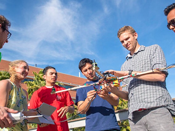 Students further developing skills by working on a drone
