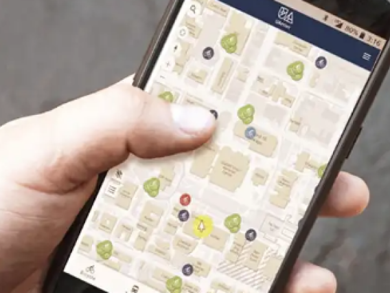 ae888 student holding a phone navigating an interactive map